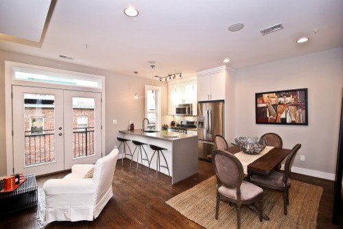 Eat-in kitchen - small transitional galley dark wood floor eat-in kitchen idea in DC Metro with an undermount sink, flat-panel cabinets, white cabinets, stainless steel appliances, an island and quartz countertops
