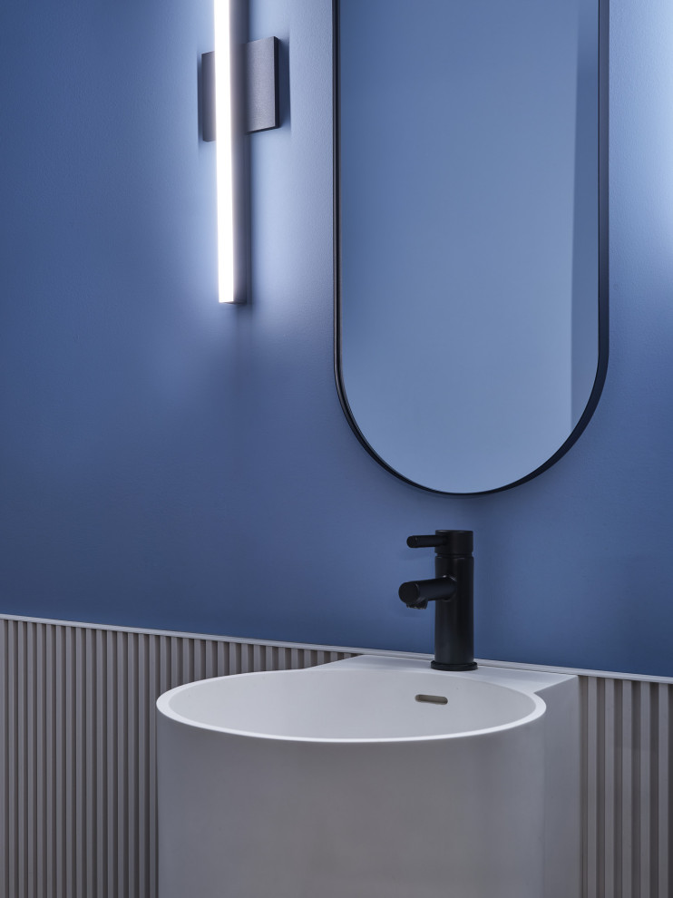 Photo of a contemporary powder room in Toronto with white cabinets, a one-piece toilet, blue tile, blue walls, porcelain floors, a wall-mount sink, black floor, a floating vanity and panelled walls.