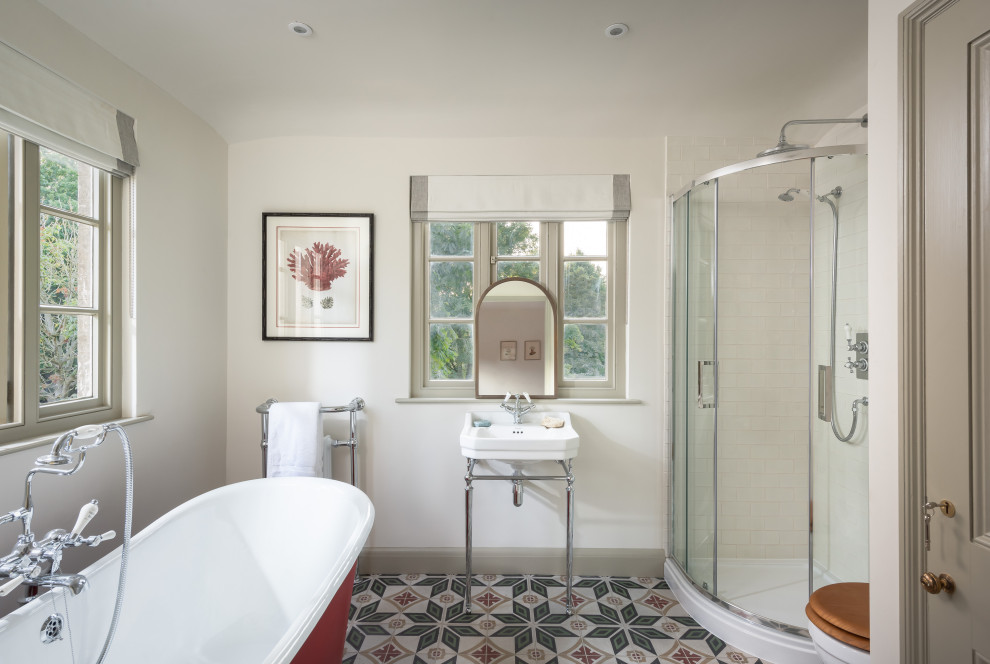 Inredning av ett klassiskt mellanstort en-suite badrum, med ett badkar med tassar, vita väggar, klinkergolv i keramik, ett piedestal handfat och flerfärgat golv