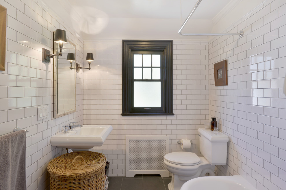 Design ideas for a mid-sized industrial kids bathroom in New York with a corner tub, a two-piece toilet, white tile, porcelain tile, white walls, slate floors and a pedestal sink.