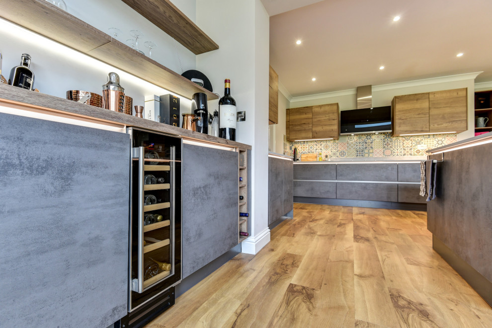 Large minimalist galley light wood floor and brown floor eat-in kitchen photo in Sussex with an undermount sink, flat-panel cabinets, medium tone wood cabinets, quartzite countertops, multicolored backsplash, ceramic backsplash, black appliances, two islands and white countertops