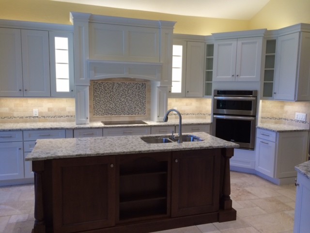 Example of a large transitional travertine floor open concept kitchen design with an undermount sink, shaker cabinets, white cabinets, quartz countertops, beige backsplash, stone tile backsplash, stainless steel appliances and an island