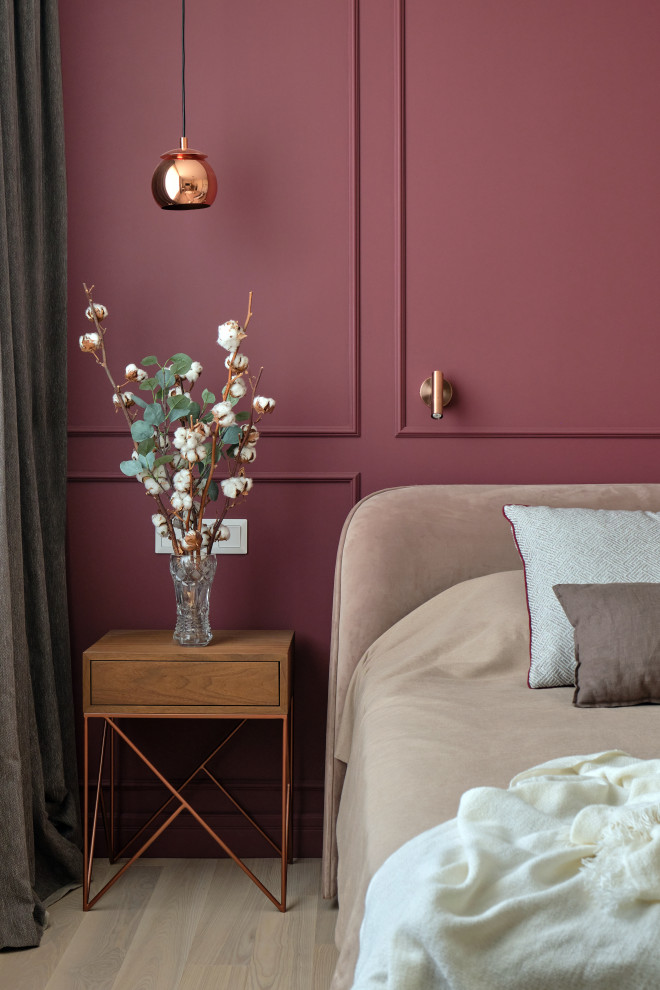 Imagen de dormitorio principal urbano de tamaño medio con paredes rojas, suelo de madera clara y suelo beige