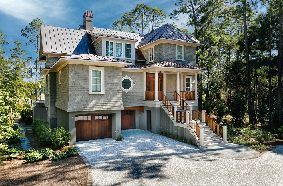 This is an example of a beach style three-storey grey house exterior in Charleston with wood siding and a metal roof.
