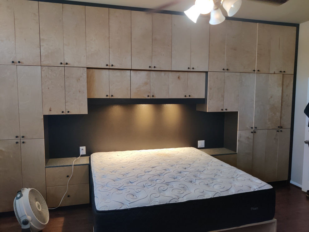 Ejemplo de dormitorio principal minimalista con paredes beige, suelo laminado y suelo marrón