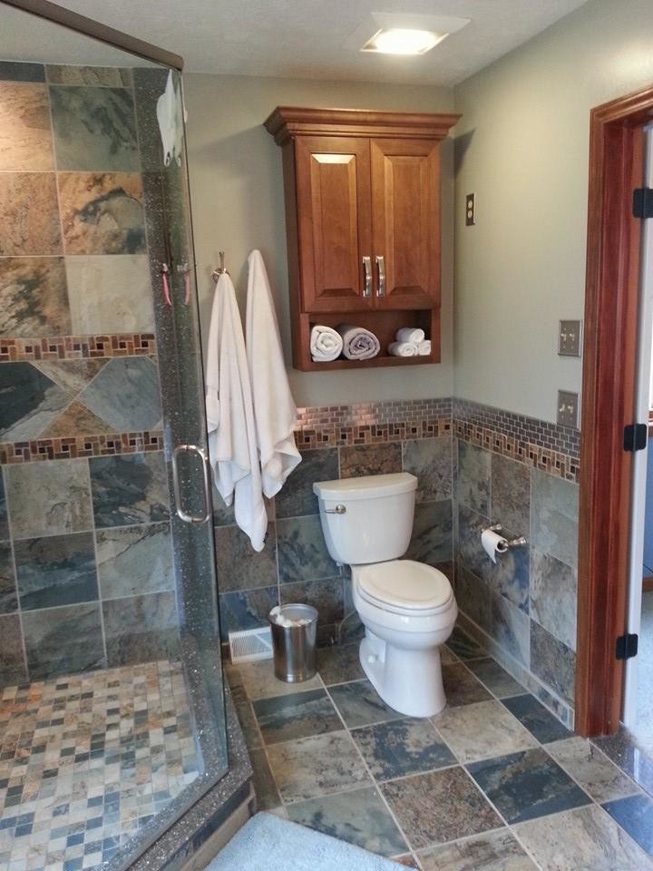 Inspiration for a mid-sized transitional master porcelain tile and multicolored tile porcelain tile home design remodel in Cleveland with raised-panel cabinets, medium tone wood cabinets, a two-piece toilet, gray walls, an undermount sink and quartz countertops