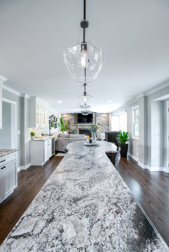 Inspiration for a mid-sized transitional u-shaped dark wood floor and brown floor open concept kitchen remodel in Chicago with a double-bowl sink, shaker cabinets, white cabinets, quartz countertops, blue backsplash, porcelain backsplash, stainless steel appliances, an island and gray countertops