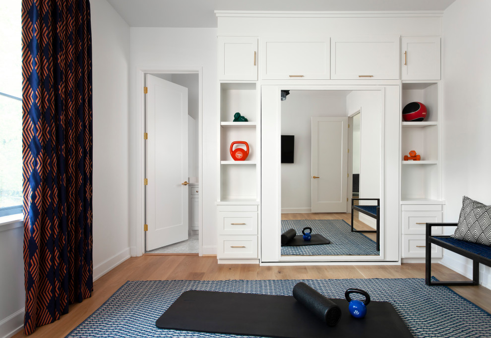 Mittelgroßer Moderner Fitnessraum mit Indoor-Sportplatz, weißer Wandfarbe und braunem Holzboden in Austin