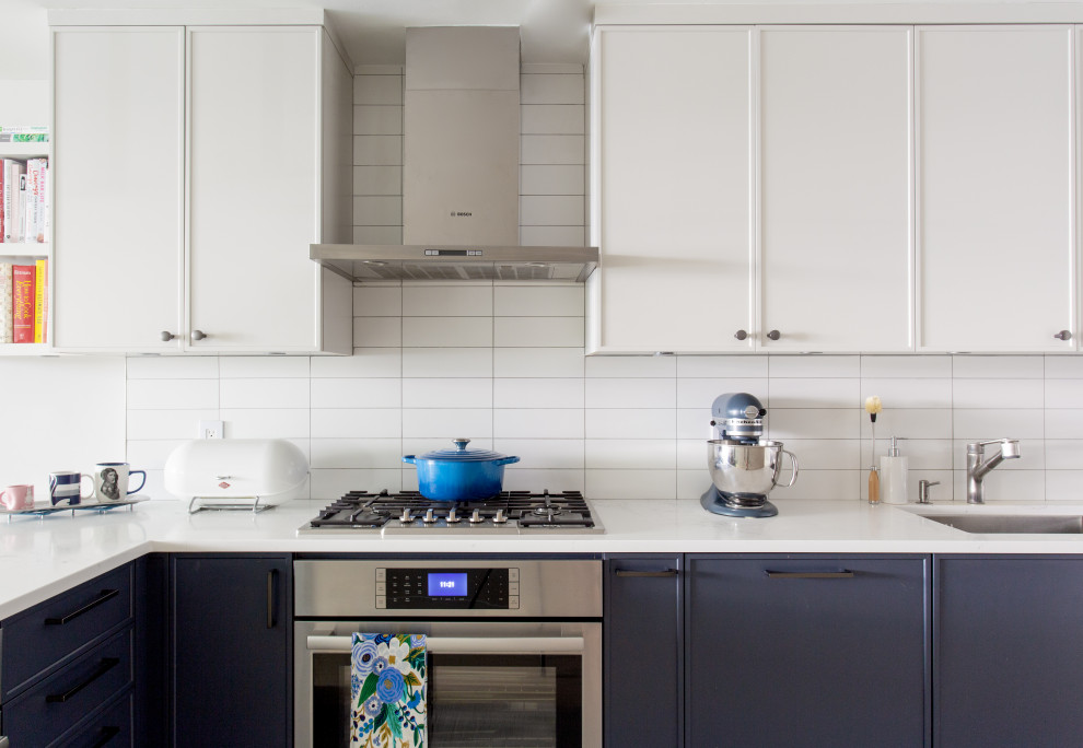 Modern inredning av ett litet vit vitt u-kök, med en nedsänkt diskho, skåp i shakerstil, vita skåp, bänkskiva i koppar, vitt stänkskydd, stänkskydd i keramik, integrerade vitvaror, mellanmörkt trägolv, en köksö och vitt golv