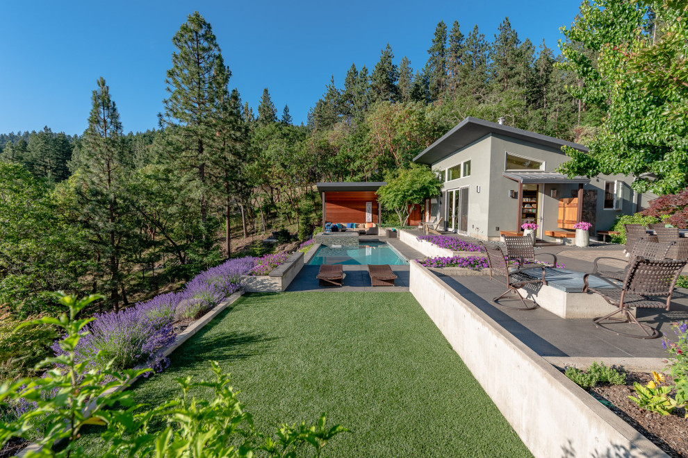 Example of a large minimalist gray one-story stucco house exterior design in Other with a butterfly roof and a metal roof