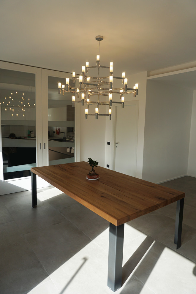 Photo of an expansive contemporary open plan dining in Other with white walls, porcelain floors and grey floor.