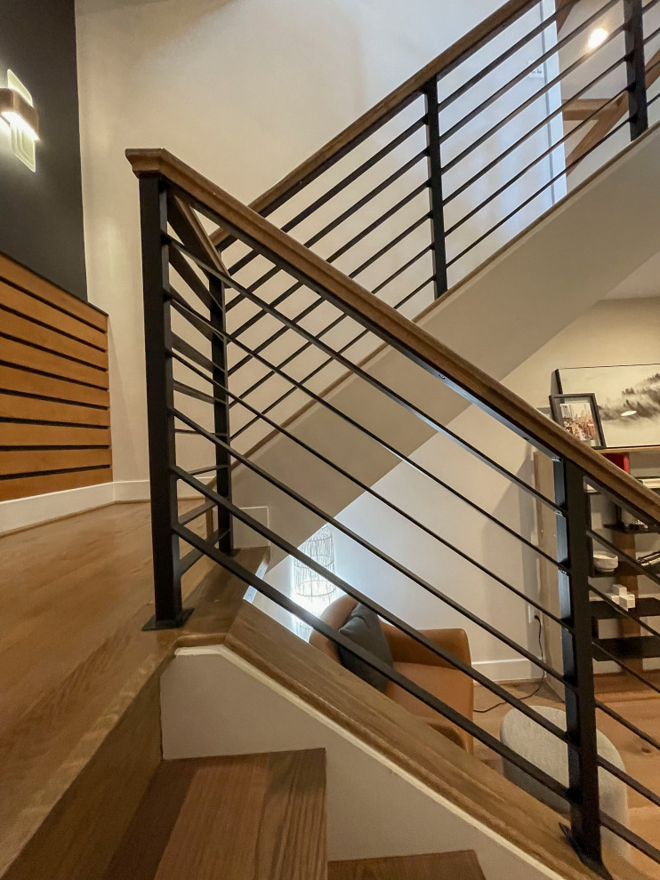 Réalisation d'un grand escalier droit design avec des marches en bois, un garde-corps en matériaux mixtes et du lambris.