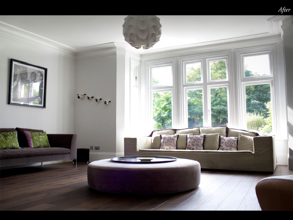 Photo of a large transitional formal open concept living room in London with white walls.