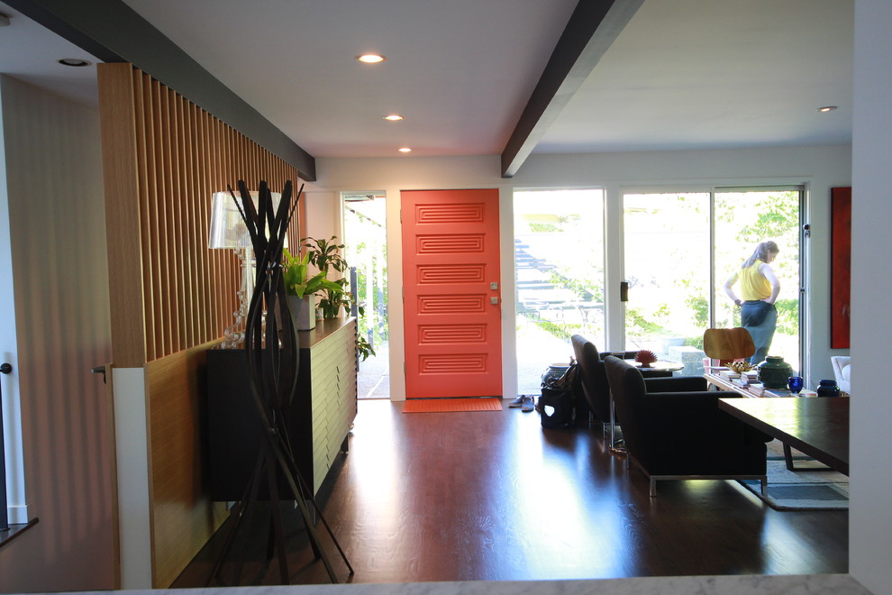 Inspiration for a mid-sized midcentury foyer in Seattle with white walls, dark hardwood floors, a single front door, an orange front door and brown floor.