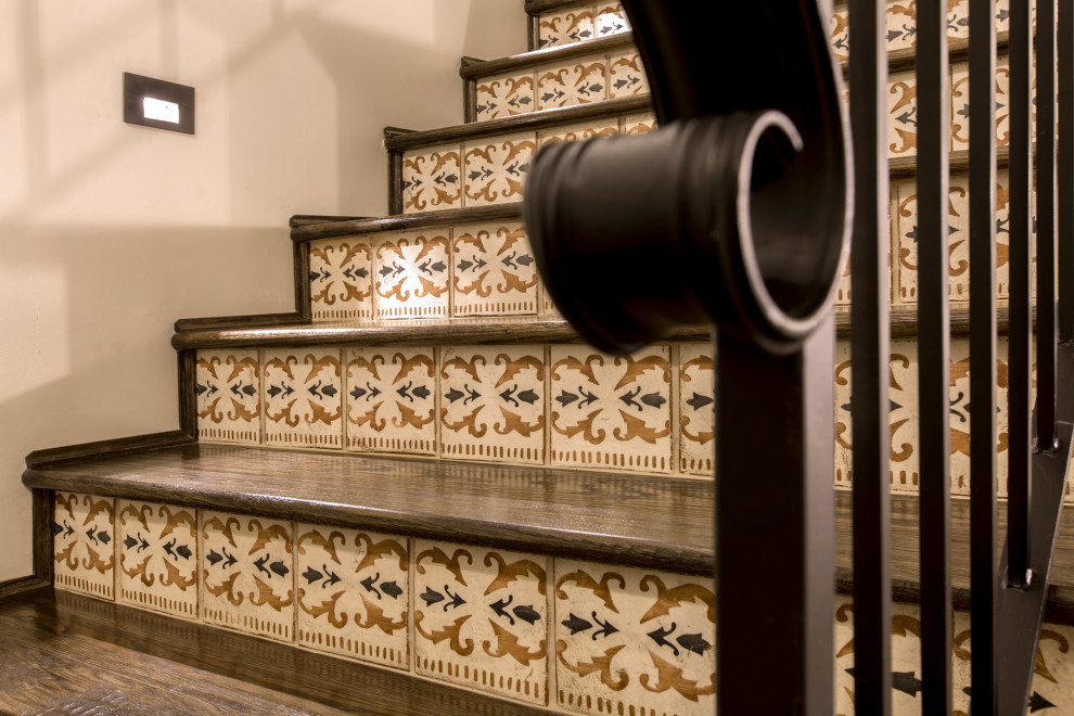 ダラスにある地中海スタイルのおしゃれな階段 (テラコッタの蹴込み板、金属の手すり) の写真