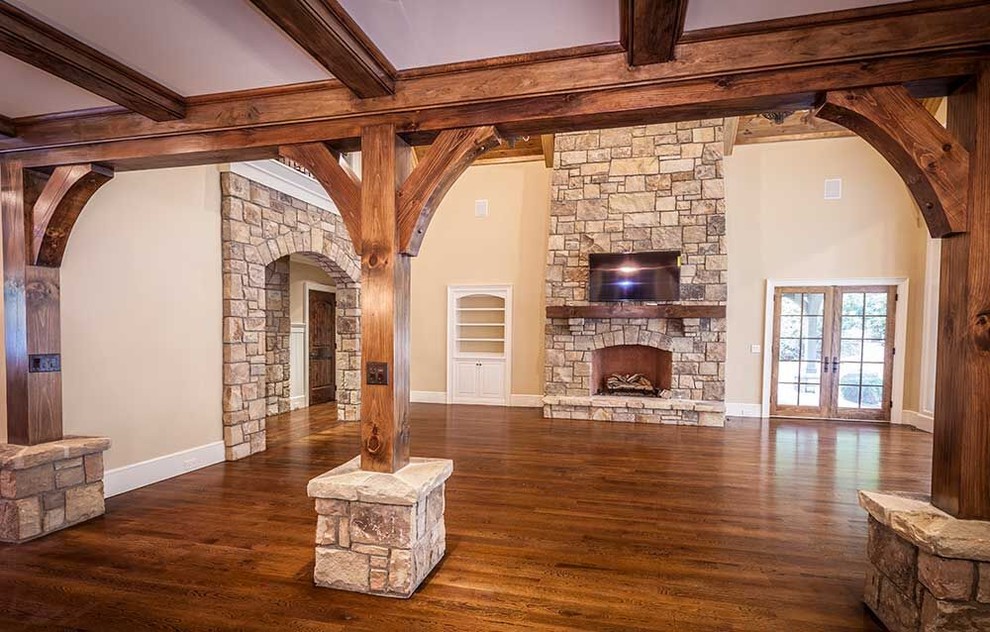 Large contemporary formal open concept living room in Charlotte with beige walls, medium hardwood floors, a standard fireplace, a stone fireplace surround and a wall-mounted tv.