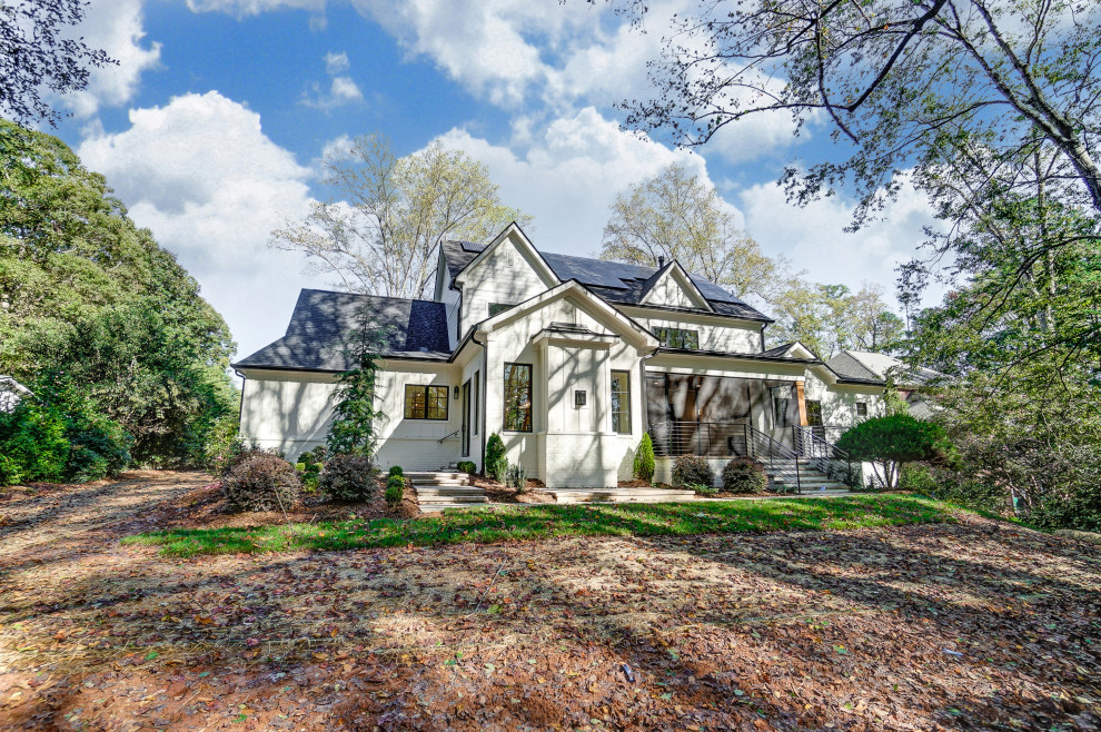 Großes, Zweistöckiges Landhaus Einfamilienhaus mit gestrichenen Ziegeln, weißer Fassadenfarbe, Satteldach, Schindeldach, schwarzem Dach und Wandpaneelen in Charlotte