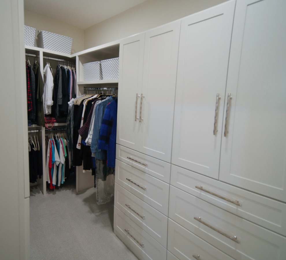 Inspiration for a small modern gender-neutral walk-in wardrobe in Other with recessed-panel cabinets, white cabinets, carpet and beige floor.