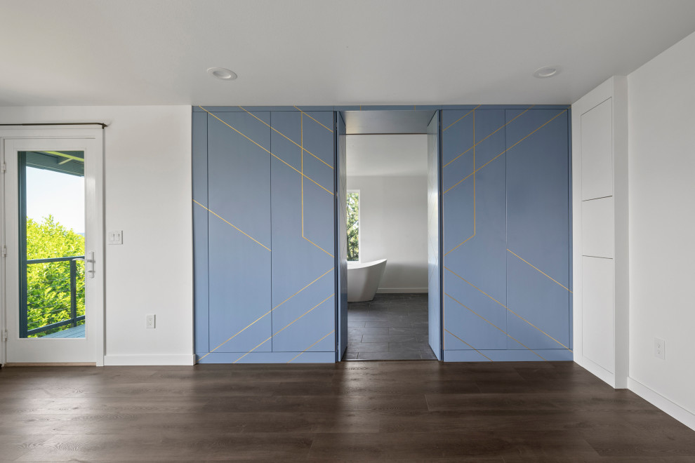 Example of a large transitional single-wall vinyl floor, brown floor and vaulted ceiling open concept kitchen design in Seattle with an undermount sink, shaker cabinets, white cabinets, quartz countertops, white backsplash, quartz backsplash, stainless steel appliances, an island and white countertops