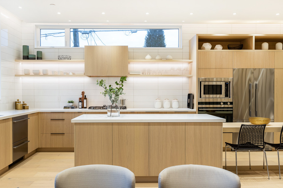 This is an example of a small contemporary l-shaped eat-in kitchen in Vancouver with a drop-in sink, flat-panel cabinets, beige cabinets, wood benchtops, white splashback, porcelain splashback, stainless steel appliances, light hardwood floors, with island, beige floor and beige benchtop.