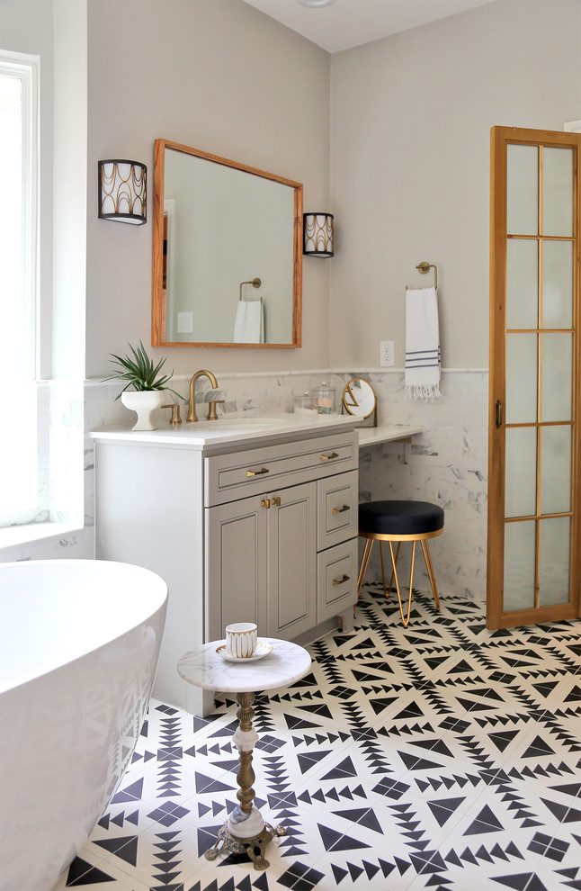 Photo of a mid-sized midcentury master bathroom in Other with raised-panel cabinets, grey cabinets, a freestanding tub, white tile, porcelain tile, white walls, mosaic tile floors, a drop-in sink, quartzite benchtops, white floor, white benchtops, a single vanity and a built-in vanity.