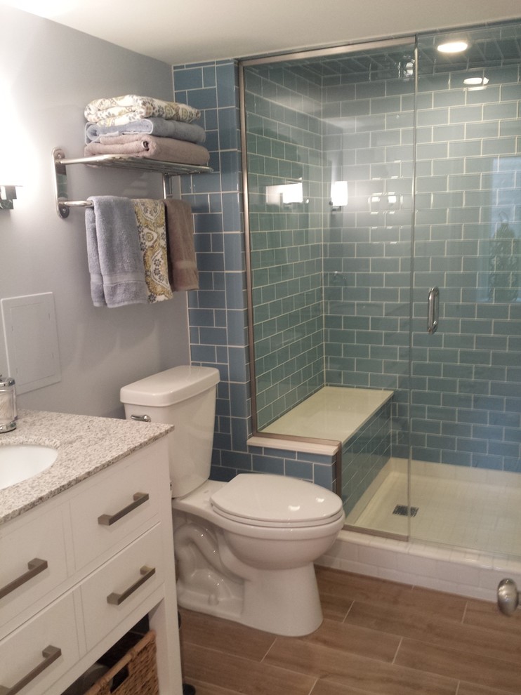 Small contemporary 3/4 bathroom in St Louis with flat-panel cabinets, white cabinets, an alcove shower, a two-piece toilet, blue tile, glass tile, blue walls, porcelain floors, an undermount sink and granite benchtops.