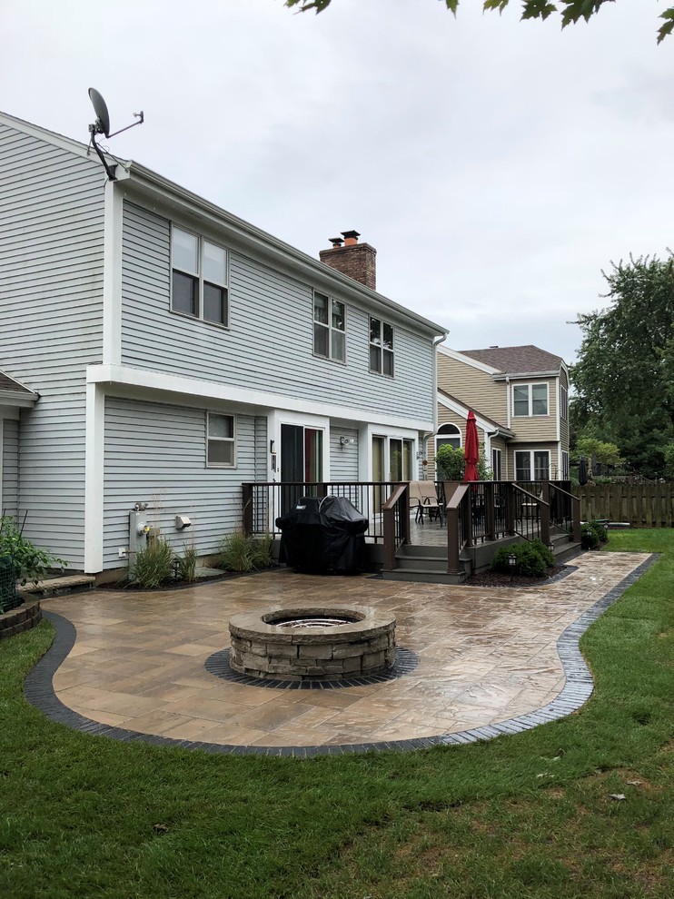 Inspiration for a mid-sized traditional backyard patio in Chicago with a fire feature, concrete pavers and no cover.