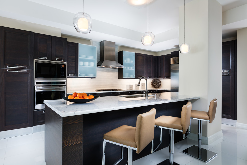Mid-sized modern l-shaped kitchen in Miami with a single-bowl sink, recessed-panel cabinets, marble benchtops, white splashback, stainless steel appliances, porcelain floors, with island, white floor, white benchtop and dark wood cabinets.