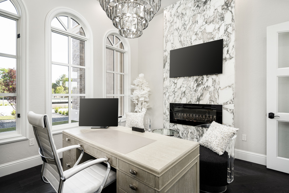 Foto de despacho minimalista extra grande con paredes blancas, suelo de madera oscura, chimenea lineal, marco de chimenea de piedra, escritorio independiente, suelo negro, casetón y panelado