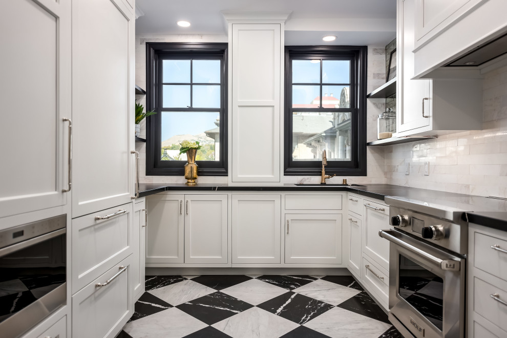 Exempel på ett litet klassiskt svart svart u-kök, med en undermonterad diskho, luckor med profilerade fronter, vita skåp, bänkskiva i kvarts, vitt stänkskydd, stänkskydd i marmor, integrerade vitvaror, marmorgolv och flerfärgat golv