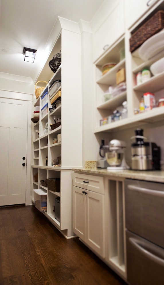 Kitchen pantry - large rustic galley medium tone wood floor kitchen pantry idea with an undermount sink, white cabinets, granite countertops, beige backsplash, stone tile backsplash and stainless steel appliances
