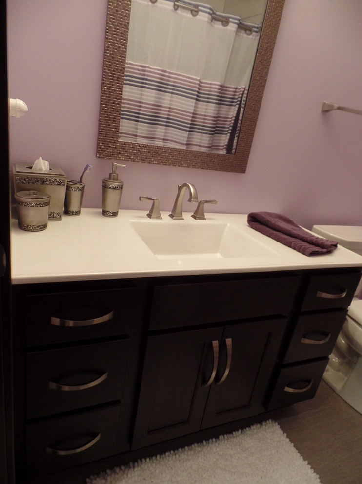 Example of a mid-sized transitional master beige floor alcove bathtub design in Cedar Rapids with shaker cabinets, dark wood cabinets, a one-piece toilet, pink walls, an integrated sink and quartz countertops