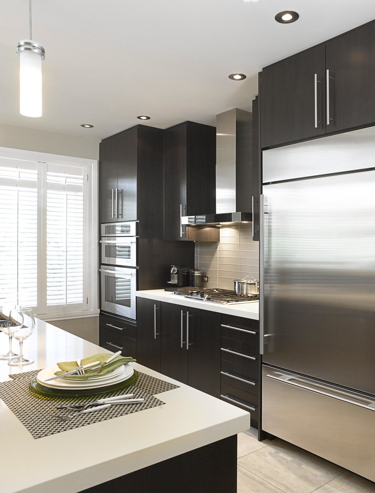 Enclosed kitchen - mid-sized modern single-wall ceramic tile enclosed kitchen idea in Montreal with an undermount sink, flat-panel cabinets, brown cabinets, quartzite countertops, white backsplash, porcelain backsplash, stainless steel appliances and an island