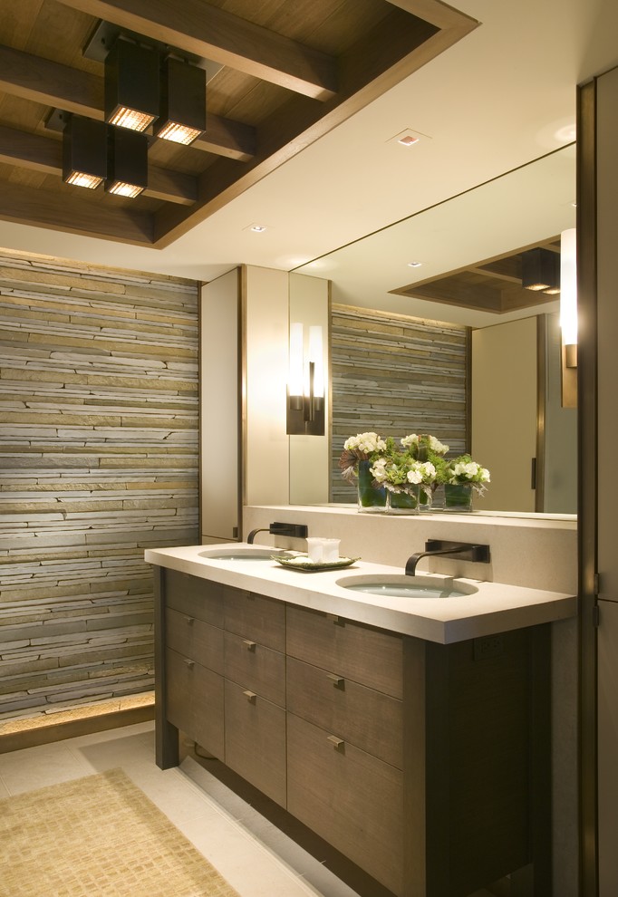 Mid-sized contemporary master bathroom in Seattle with flat-panel cabinets, dark wood cabinets, gray tile, stone tile, grey walls, concrete floors, an undermount sink, solid surface benchtops, grey floor and beige benchtops.