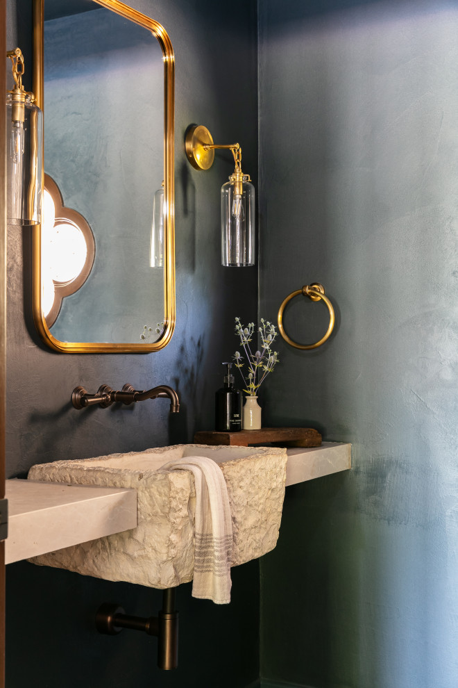 Small tuscan dark wood floor and brown floor powder room photo in Santa Barbara with a one-piece toilet, blue walls, a wall-mount sink, marble countertops, beige countertops and a floating vanity