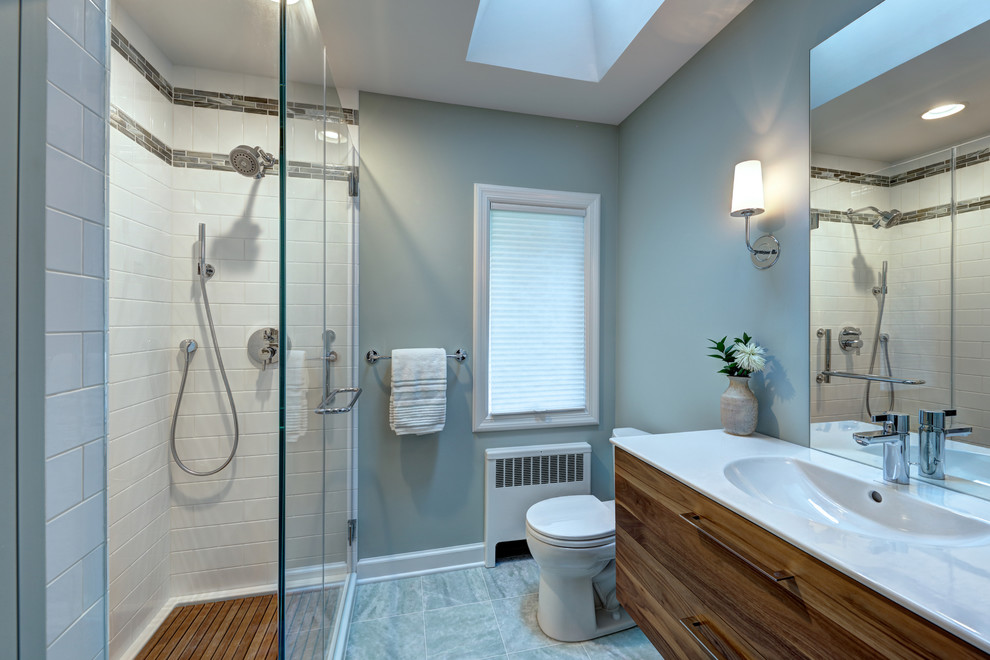 Small transitional master bathroom in New York with flat-panel cabinets, medium wood cabinets, white tile, ceramic tile, glass benchtops, a two-piece toilet, green walls, marble floors, an integrated sink and green floor.