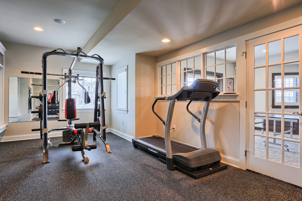 This is an example of an expansive traditional home gym in Other with beige walls and carpet.