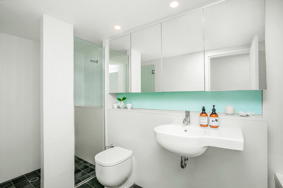 Small contemporary master bathroom in Sydney with an open shower, a wall-mount toilet, white tile, white walls, an integrated sink and limestone benchtops.