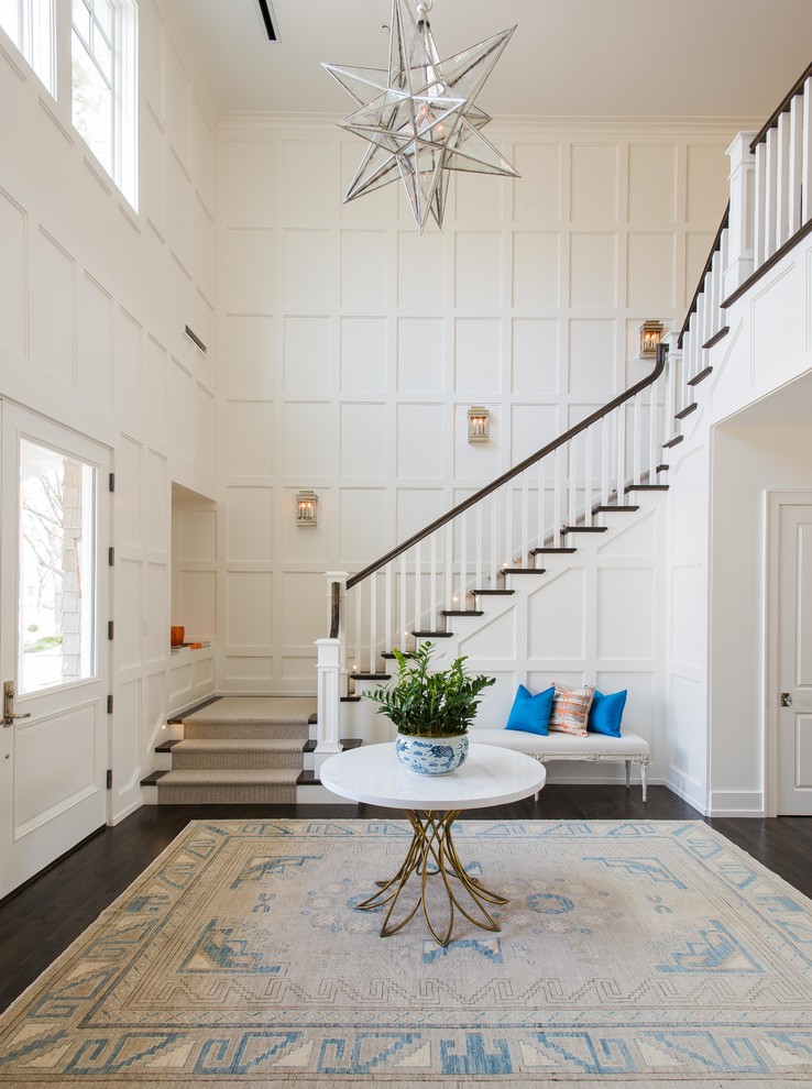 This is an example of a large transitional wood u-shaped staircase in Dallas with painted wood risers and wood railing.