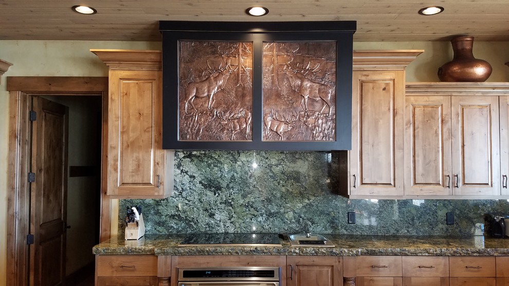 This is an example of an arts and crafts kitchen in Other with raised-panel cabinets, medium wood cabinets, granite benchtops, green splashback, stone slab splashback and green benchtop.
