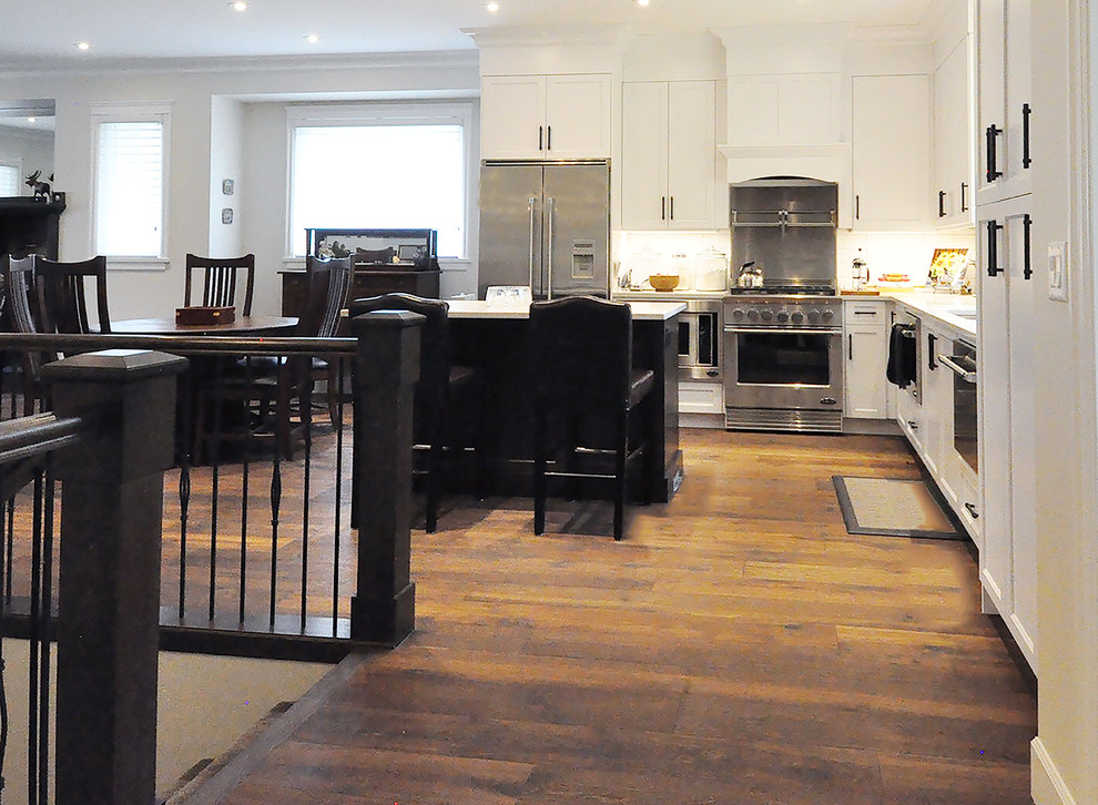 Inspiration for a transitional dark wood floor kitchen remodel in Vancouver with white cabinets, stainless steel appliances and an island
