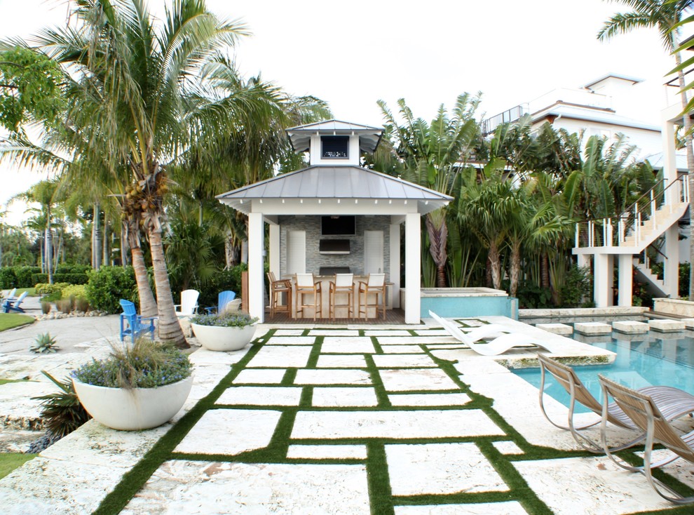 Large contemporary backyard custom-shaped pool in Tampa with a water feature and natural stone pavers.