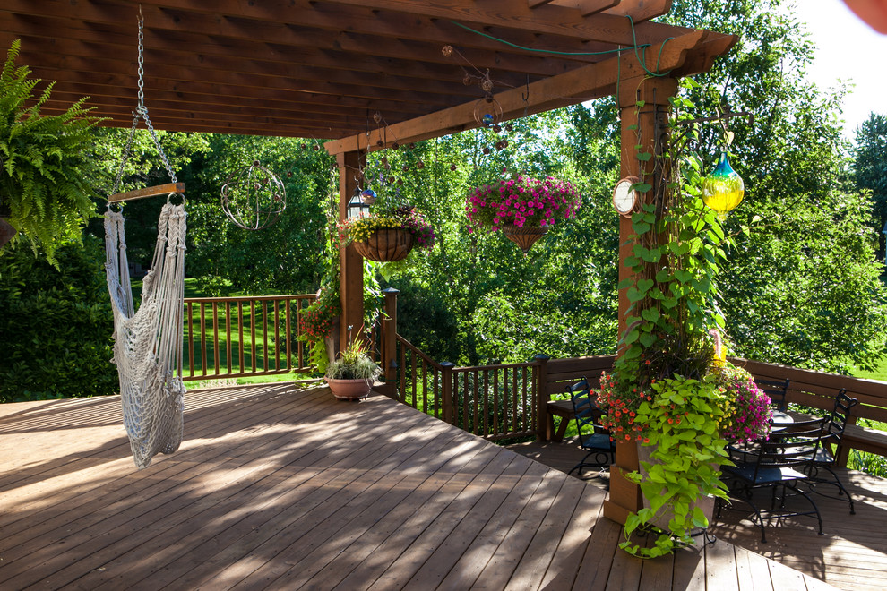 This is an example of a large traditional backyard deck in Chicago with a pergola.