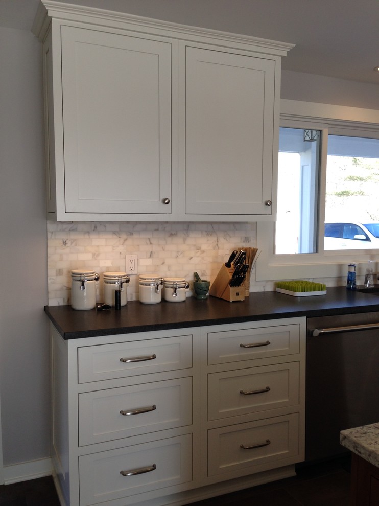 This is an example of a large arts and crafts eat-in kitchen in Cleveland with white cabinets, stainless steel appliances, with island, beaded inset cabinets, granite benchtops, grey splashback and stone tile splashback.
