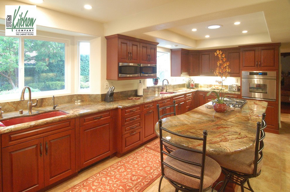 Photo of a large transitional u-shaped separate kitchen in San Luis Obispo with an undermount sink, raised-panel cabinets, stone slab splashback, stainless steel appliances, red cabinets, marble benchtops, green splashback, travertine floors, with island, yellow floor, green benchtop and recessed.