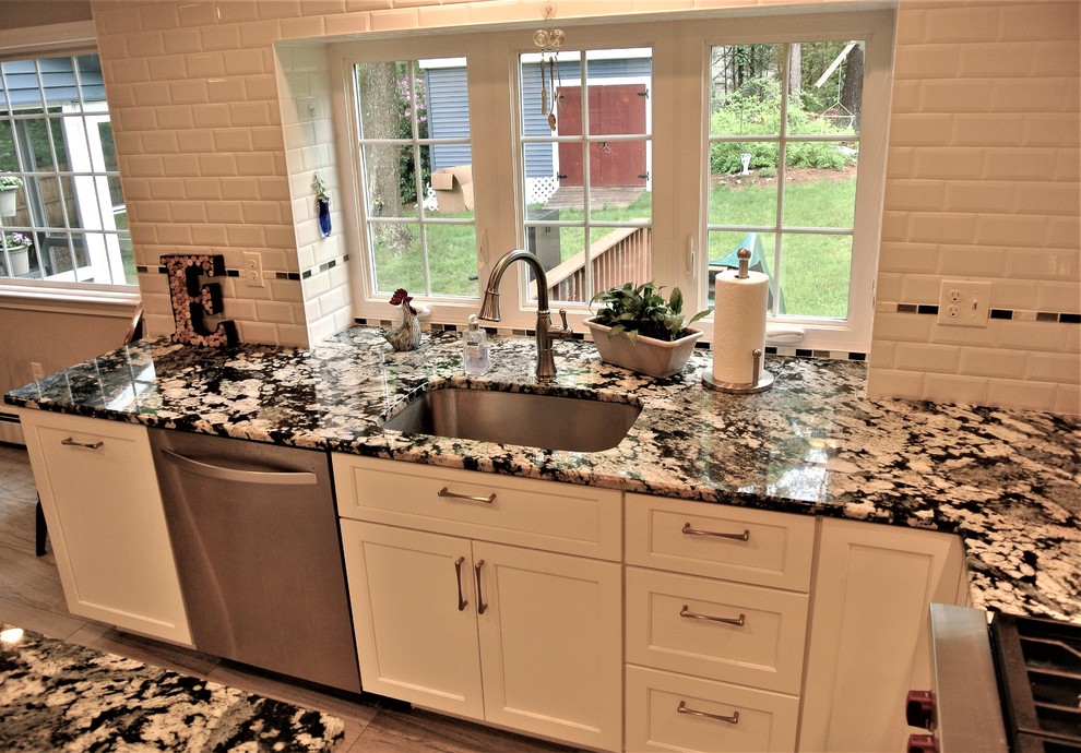 Inspiration for a transitional kitchen remodel in Boston with an undermount sink, shaker cabinets, granite countertops, subway tile backsplash, stainless steel appliances and an island
