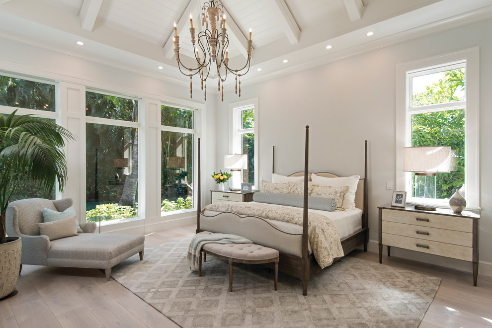 Inspiration for a transitional master bedroom in Miami with white walls and light hardwood floors.