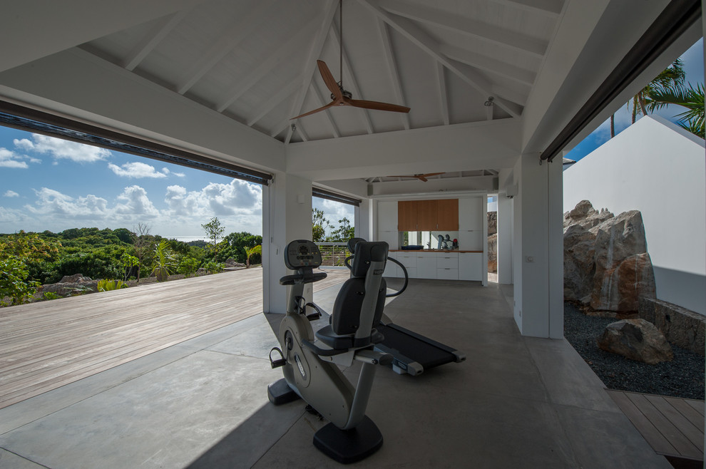 This is an example of a tropical multipurpose gym in Other with white walls and concrete floors.