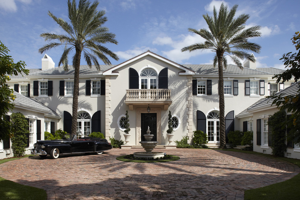 This is an example of a large traditional two-storey white exterior in Miami with a hip roof.