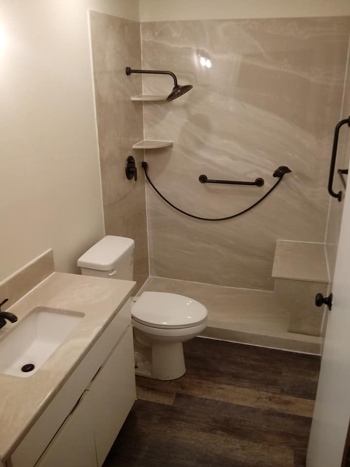 Photo of a mid-sized modern 3/4 bathroom in Dallas with a one-piece toilet, beige tile, marble, wood-look tile, marble benchtops, brown floor, a shower seat, a single vanity, a built-in vanity, an undermount sink and a sliding shower screen.
